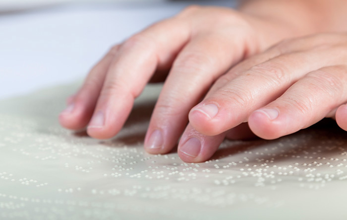 Fingers reading braille print